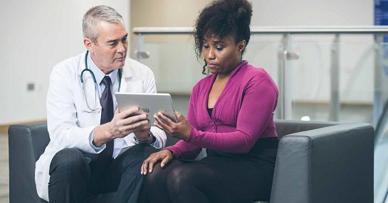 Doctor using tablet with patient
