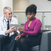 Doctor using tablet with patient