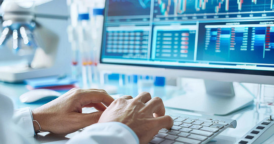 hands on computer with data on screen