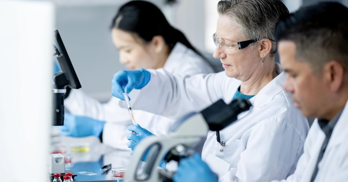 lab workers sampling looking at microscopes