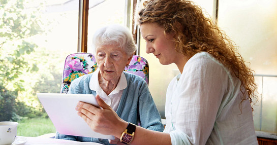 Alzheimer's patient and nurse looking at tablet