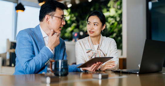 man and woman discussing with tablet and laptop